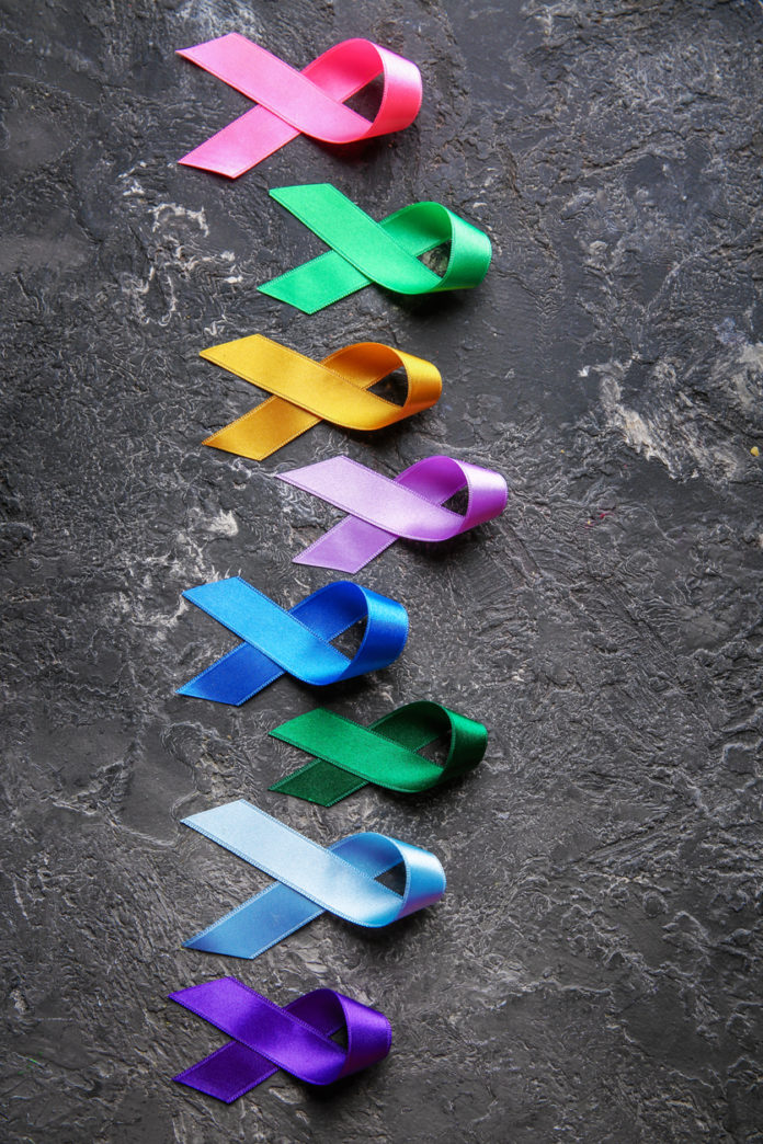 Different colorful ribbons on grunge background. Cancer concept