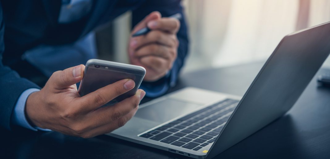 Business man use smartphone with laptop computer at office artificial intelligence technology global iot providing virtual, customer support and information.